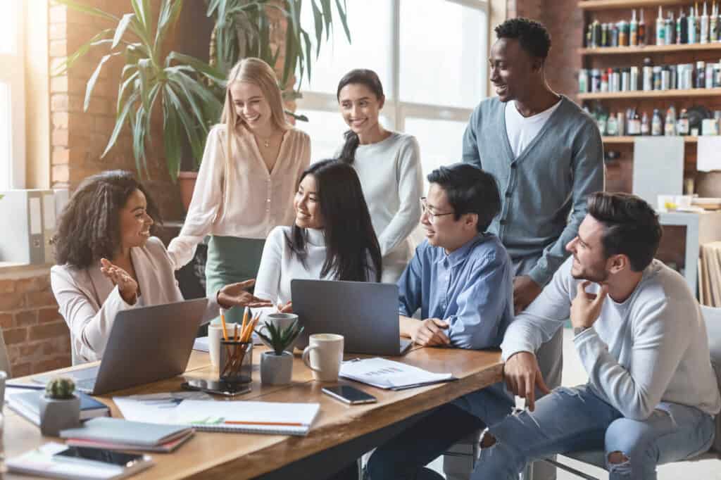 A group of young professionals attend a work presentation in an office