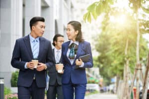 coworkers walking on city street and chatting