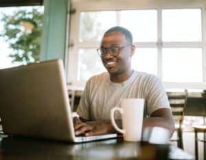 generation z student looking at laptop and smiling