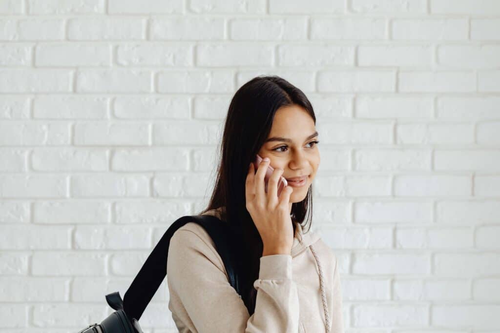 student smiling with phone to her ear