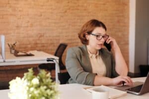 student on phone sitting in front of a keyboard declining a job offer