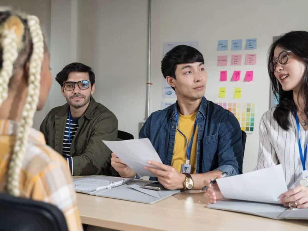 Company employees sitting at a table, facing an interviewee