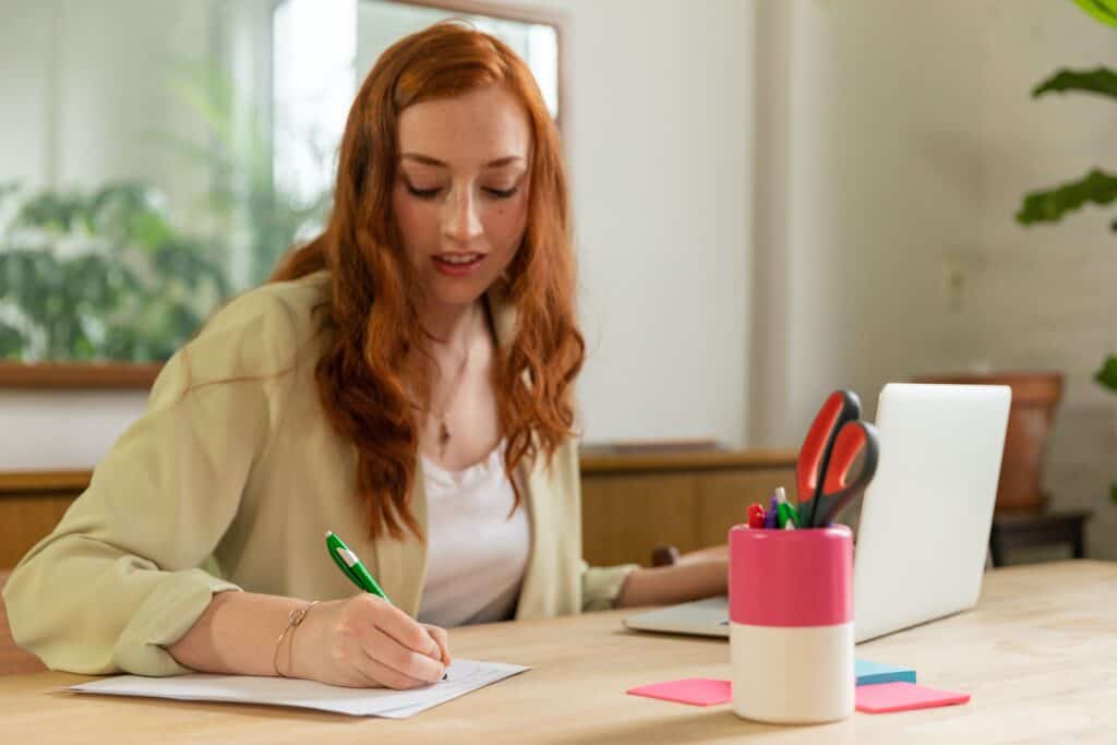 woman writing down notes while on the job search