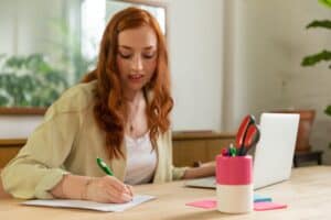 woman writing down notes while on the job search