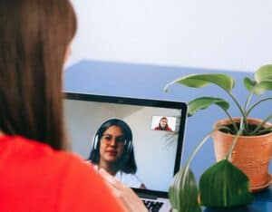 woman in virtual interview looking at recruiter with headphones on