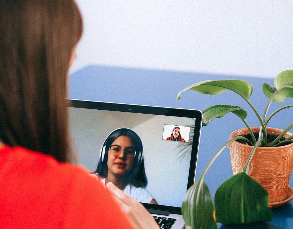 woman in virtual interview looking at recruiter with headphones on