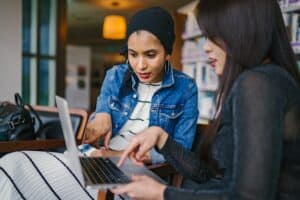 two coworkers discussing something over a laptop