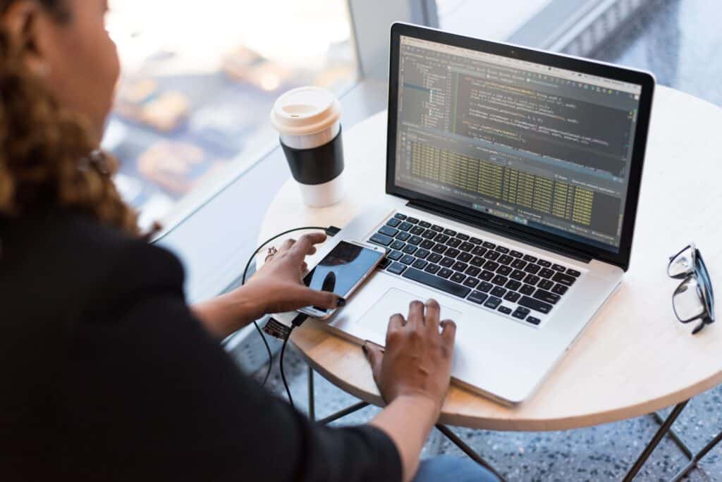 woman using programming skills to code on her laptop